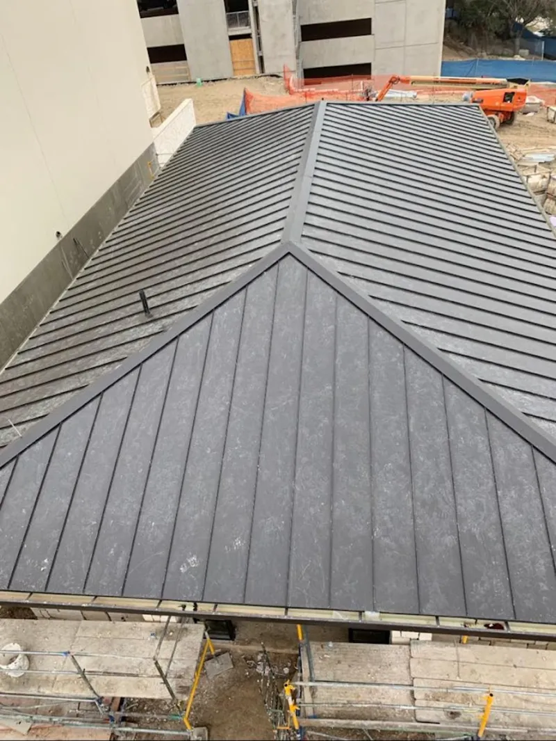 Commercial metal roof construction with crane equipment in Rogersville